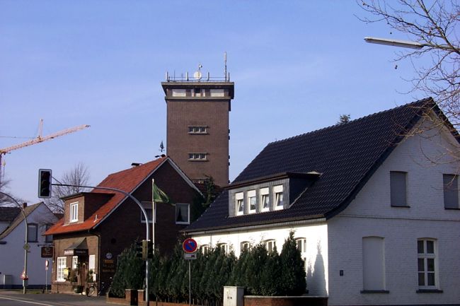 Hinter den Husern ragt der Wasserturm in die Hhe