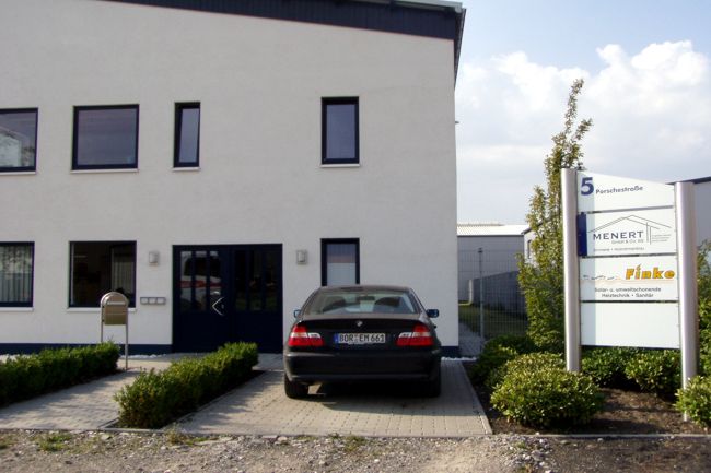 Neben dem Firmengebude erkennt man ein Schild das auf die ansssigen Firmen hinweist