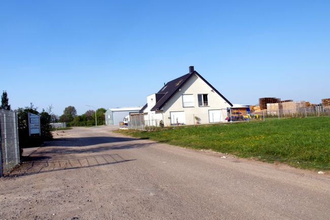 Neben dem Haus erkennt man das Paletten-Lager von Ken Paletten