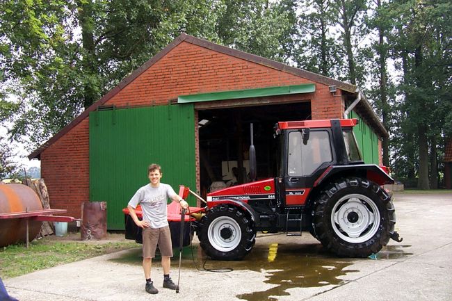 Ein Landwirt posiert vor seinem frisch gewaschenen Traktor