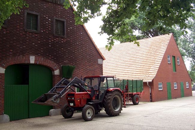 Ein lterer Traktor vor einer groen Scheune