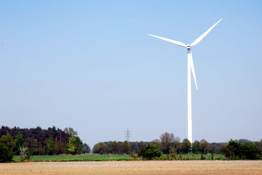 Blick ber einen Feldweg auf eine Windkraftanlage